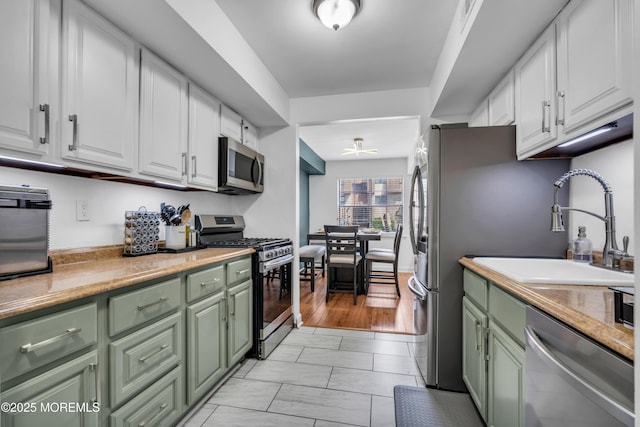 193 Sierra Ct, Woodbridge, NJ 07095 - kitchen with green cabinetry, stainless steel appliances, and white cabinetry