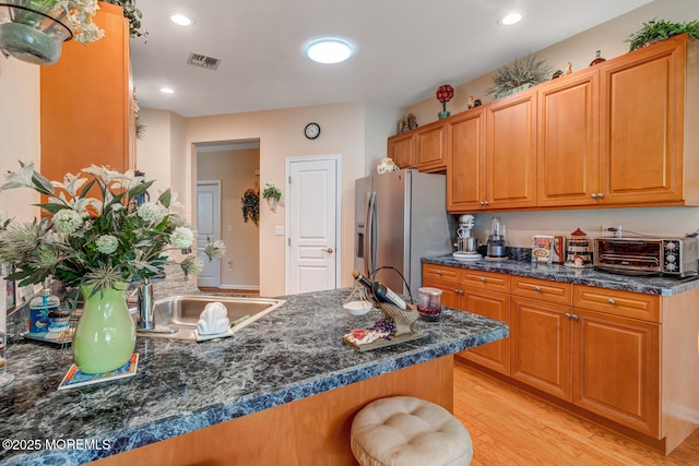 41 Sunrise Bay Blvd, Little Egg Harbor, NJ 08087 - kitchen featuring stainless steel fridge with ice dispenser, light wood-style flooring, a peninsula, a breakfast bar, and brown cabinetry