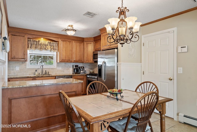 54 Storm Jib Ct, Bayville, NJ 08721 - kitchen with stainless steel appliances, baseboard heating, brown cabinetry, a chandelier, and decorative backsplash