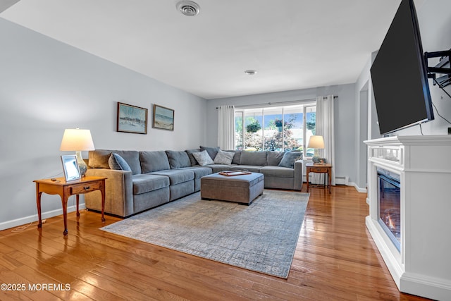23 Auburn Rd, Toms River, NJ 08757 - living room with wood-type flooring, a baseboard heating unit, and a glass covered fireplace