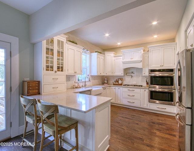 74 Squankum Rd, Tinton Falls, NJ 07724 - kitchen featuring stainless steel appliances, a peninsula, white cabinets, light countertops, and dark wood finished floors