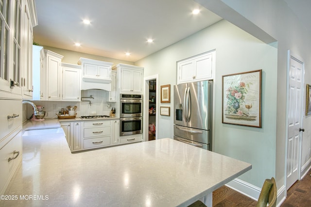 74 Squankum Rd, Tinton Falls, NJ 07724 - kitchen featuring stainless steel appliances, a peninsula, backsplash, white cabinetry, and recessed lighting