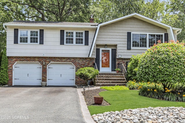 27 Greenhill Dr, Brick, NJ 08724 - split foyer home with asphalt driveway, a garage, a front lawn, brick siding, and a chimney