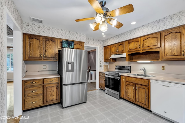 27 Greenhill Dr, Brick, NJ 08724 - kitchen with stainless steel appliances, wallpapered walls, under cabinet range hood, brown cabinetry, and light countertops