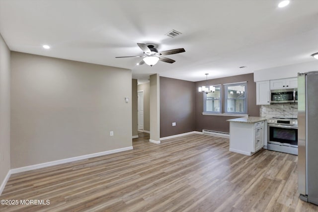 9 Deerfield Dr Unit D, Whiting, NJ 08759 - kitchen with appliances with stainless steel finishes, baseboard heating, white cabinets, light wood finished floors, and a chandelier