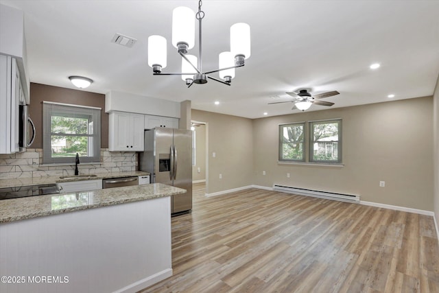 9 Deerfield Dr Unit D, Whiting, NJ 08759 - kitchen with a baseboard radiator, stainless steel appliances, backsplash, a chandelier, and light stone counters