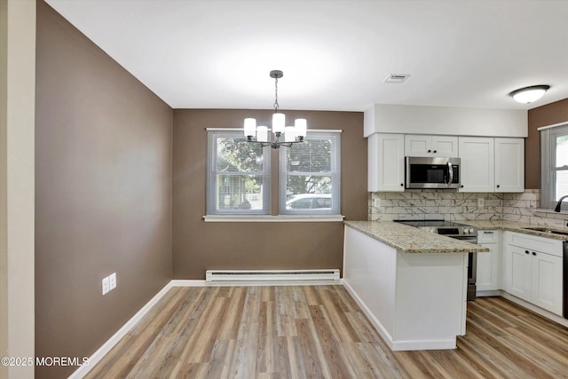 9 Deerfield Dr Unit D, Whiting, NJ 08759 - kitchen featuring appliances with stainless steel finishes, a baseboard heating unit, decorative backsplash, and white cabinetry