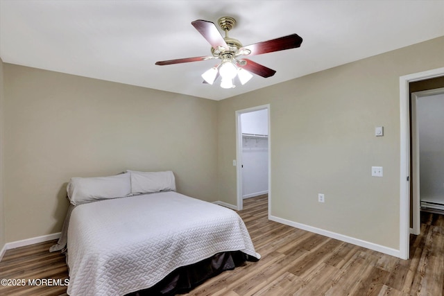 9 Deerfield Dr Unit D, Whiting, NJ 08759 - bedroom with light wood-style flooring, ceiling fan, a walk in closet, and a baseboard heating unit