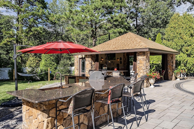 28 Stonehenge Ct, Jackson, NJ 08527 - view of patio featuring an outdoor kitchen, view of scattered trees, and an outbuilding