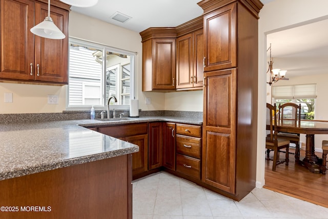 16 Saint Paul Pl, Manchester, NJ 08759 - kitchen with brown cabinets, a chandelier, decorative light fixtures, and light tile patterned floors