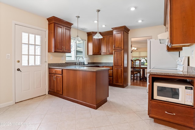 16 Saint Paul Pl, Manchester, NJ 08759 - kitchen with white microwave, a peninsula, brown cabinets, hanging light fixtures, and recessed lighting