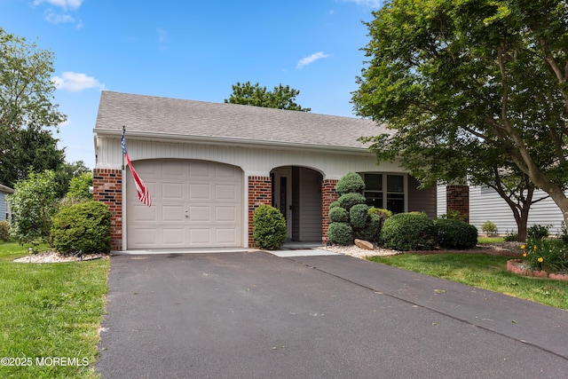 16 Saint Paul Pl, Manchester, NJ 08759 - view of front facade with brick siding, a garage, driveway, and a shingled roof