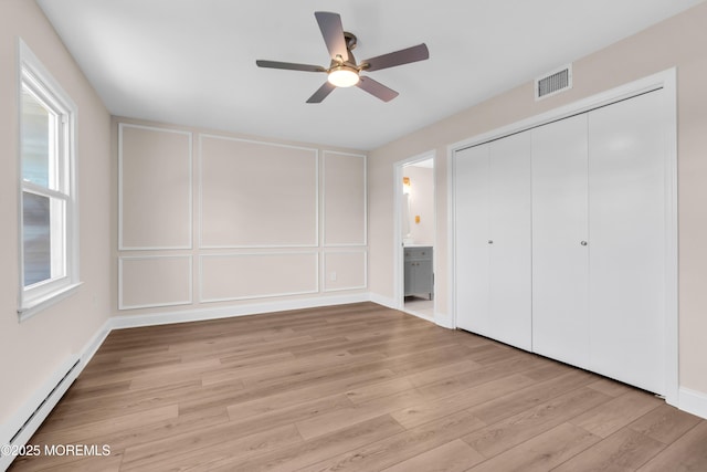 377 Old Nassau Rd Unit 377B, Monroe, NJ 08831 - unfurnished bedroom featuring baseboard heating, light wood finished floors, a decorative wall, a closet, and ensuite bath