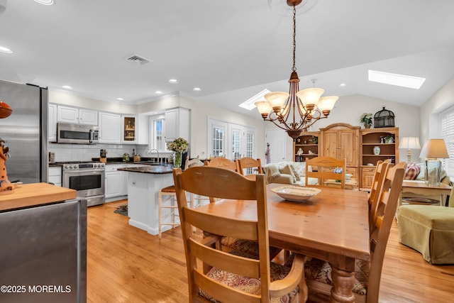217 Howe St, Point Pleasant, NJ 08742 - dining space with a skylight, a chandelier, light wood finished floors, healthy amount of natural light, and lofted ceiling