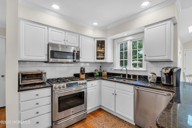 217 Howe St, Point Pleasant, NJ 08742 - kitchen with appliances with stainless steel finishes, dark stone countertops, white cabinets, tasteful backsplash, and glass insert cabinets