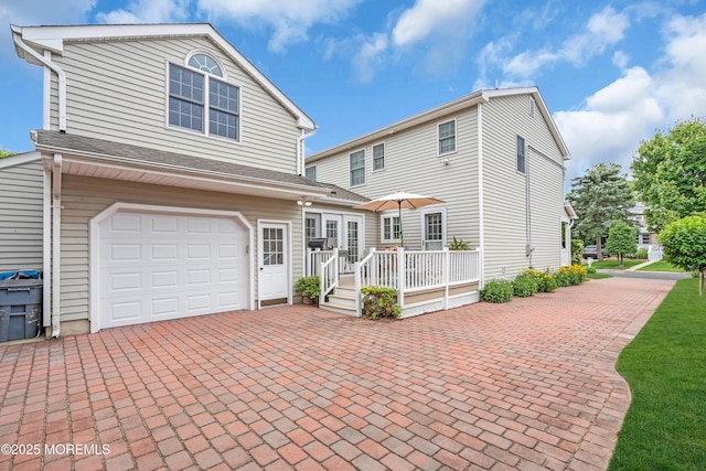 217 Howe St, Point Pleasant, NJ 08742 - view of front of property featuring decorative driveway, a deck, and a garage