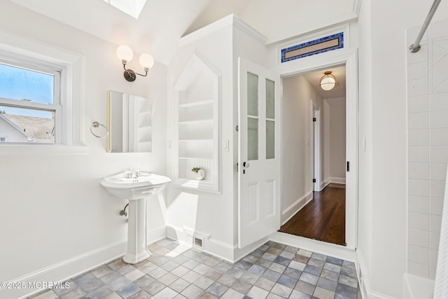 132 Cookman Ave, Ocean Grove, NJ 07756 - bathroom with stone finish floors, a shower, and a skylight