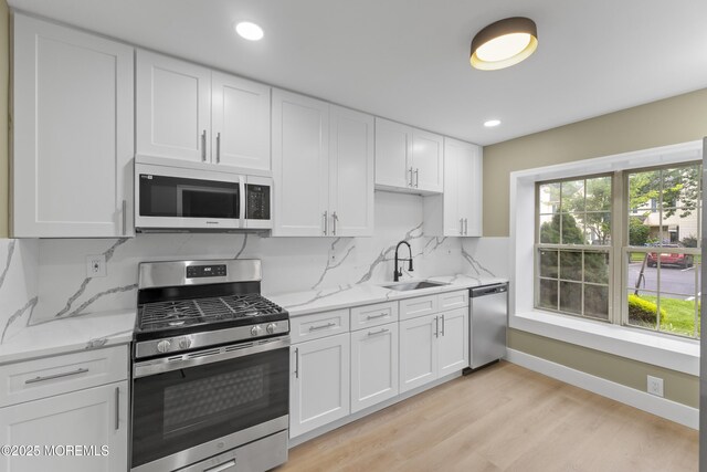 13 Stuart Dr Unit 5, Freehold, NJ 07728 - kitchen featuring appliances with stainless steel finishes, white cabinets, light wood-style flooring, light stone countertops, and recessed lighting