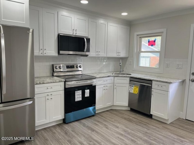 482C Thornbury Ct, Lakewood, NJ 08701 - kitchen with stainless steel appliances, ornamental molding, light wood-style floors, white cabinetry, and decorative backsplash