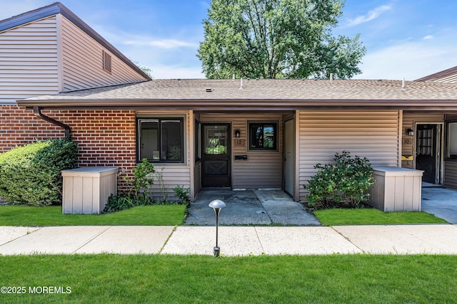 12 Ellsworth Ct, Red Bank, NJ 07701 - view of front of house with roof with shingles, brick siding, and a front yard
