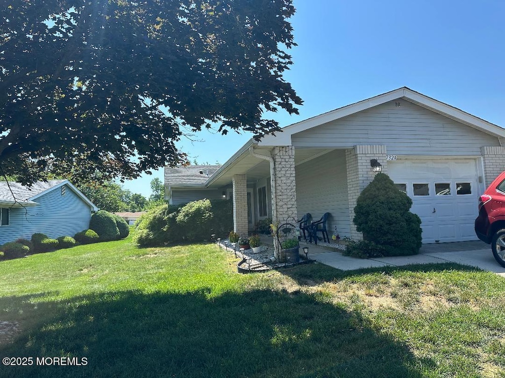 732 Ralston Plz Unit 732A, Monroe, NJ 08831 - view of property exterior with a lawn, brick siding, an attached garage, and covered porch