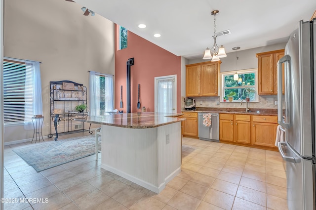 27 Skyline Dr, Hazlet, NJ 07730 - kitchen featuring stainless steel appliances, light tile patterned floors, dark stone countertops, decorative backsplash, and a kitchen island