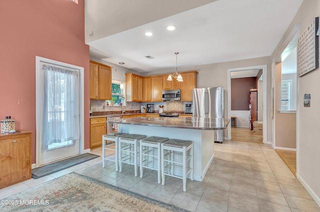 27 Skyline Dr, Hazlet, NJ 07730 - kitchen featuring appliances with stainless steel finishes, a kitchen island, a kitchen breakfast bar, light tile patterned floors, and recessed lighting