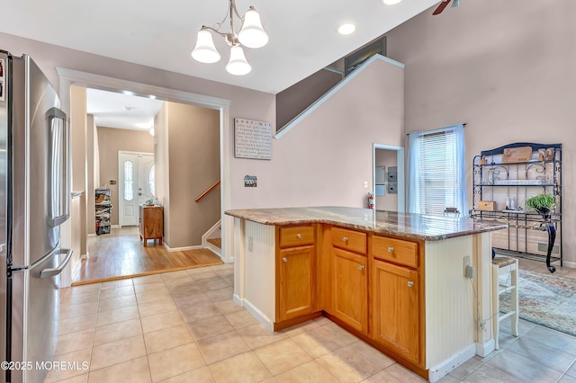 27 Skyline Dr, Hazlet, NJ 07730 - kitchen featuring freestanding refrigerator, a chandelier, light stone countertops, light tile patterned floors, and a kitchen island