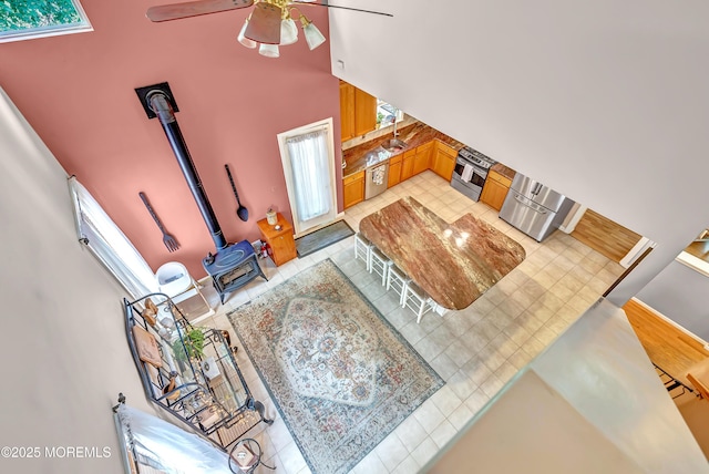 27 Skyline Dr, Hazlet, NJ 07730 - living area with a wood stove, a ceiling fan, a high ceiling, and light tile patterned floors