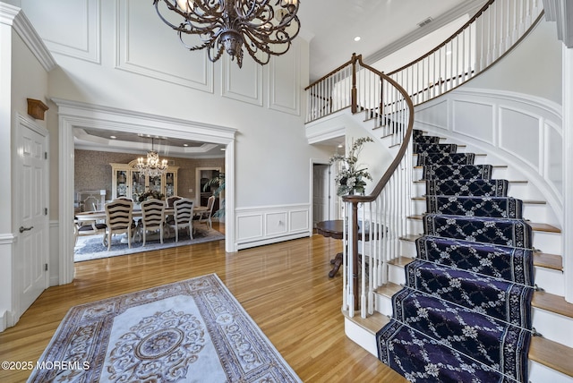 320 Sinclair Ct, Morganville, NJ 07751 - entryway featuring a chandelier, stairs, light wood finished floors, crown molding, and a decorative wall