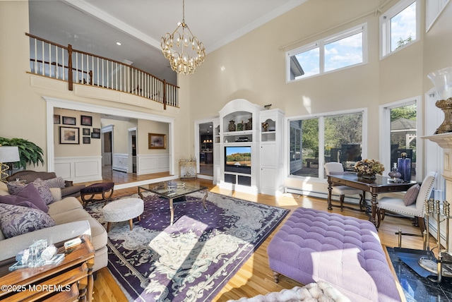 320 Sinclair Ct, Morganville, NJ 07751 - living area featuring ornamental molding, a towering ceiling, a chandelier, and wood finished floors