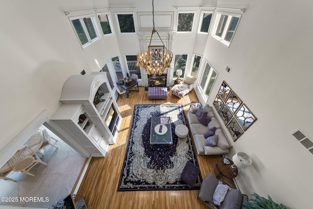 320 Sinclair Ct, Morganville, NJ 07751 - living room featuring a high ceiling, wood finished floors, a chandelier, and healthy amount of natural light