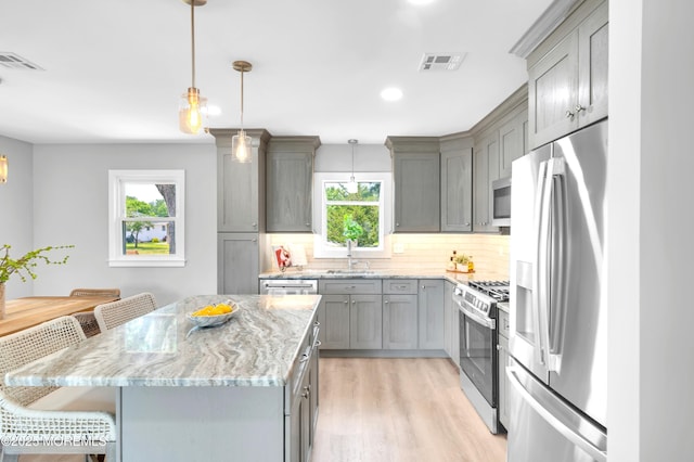 134 Northumberland Dr, Toms River, NJ 08757 - kitchen with appliances with stainless steel finishes, gray cabinets, tasteful backsplash, light wood-style flooring, and light stone counters