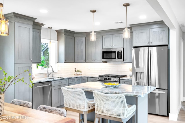 134 Northumberland Dr, Toms River, NJ 08757 - kitchen featuring stainless steel appliances, gray cabinets, light stone counters, decorative backsplash, and a breakfast bar area