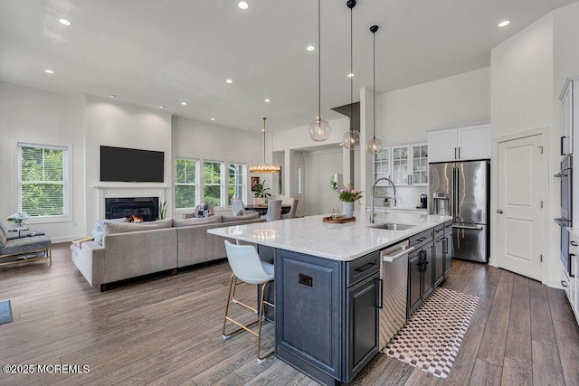 2 Foulks Ter, Lincroft, NJ 07738 - kitchen featuring appliances with stainless steel finishes, white cabinetry, dark wood-style flooring, a high ceiling, and a center island with sink