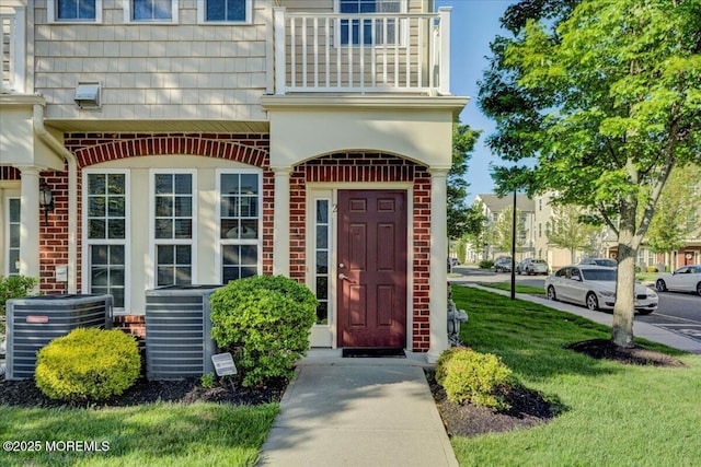 2 Michael Dr, Tinton Falls, NJ 07712 - view of exterior entry featuring a balcony, brick siding, and a lawn