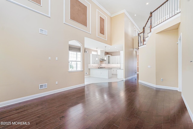 161 Arborridge Dr, Forked River, NJ 08731 - unfurnished living room with arched walkways, a high ceiling, hardwood / wood-style floors, and crown molding