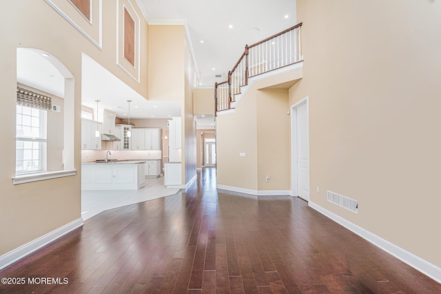 161 Arborridge Dr, Forked River, NJ 08731 - unfurnished living room featuring a towering ceiling, arched walkways, and dark wood-style floors