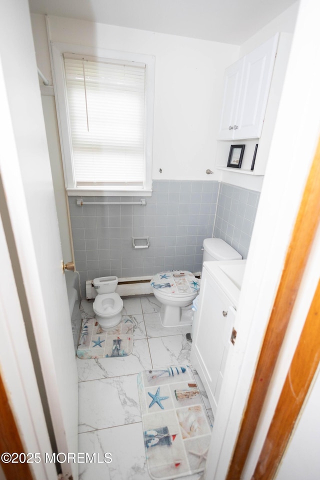 364 Westwood Ave Unit 7, Long Branch, NJ 07740 - half bath with marble look tile flooring, vanity, tile walls, and a wainscoted wall