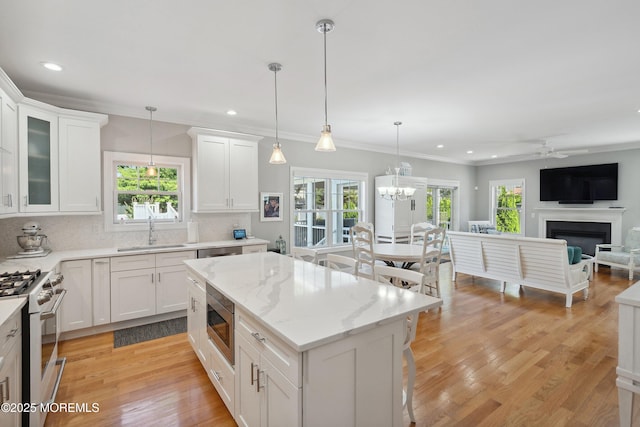 309 Hall Ave, Point Pleasant, NJ 08742 - kitchen with range with gas stovetop, stainless steel microwave, a ceiling fan, light wood-type flooring, and white cabinets