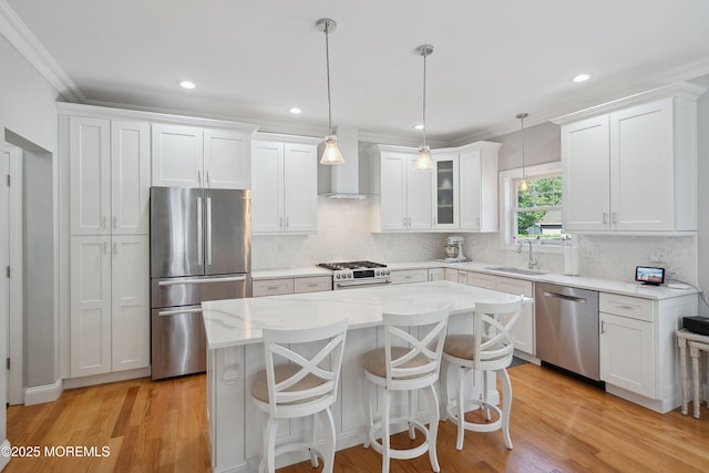 309 Hall Ave, Point Pleasant, NJ 08742 - kitchen featuring appliances with stainless steel finishes, wall chimney range hood, white cabinets, backsplash, and ornamental molding