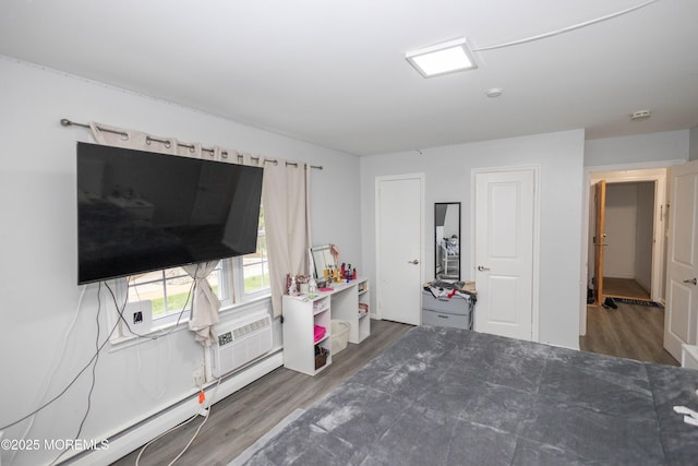 364 Westwood Ave Unit 46, Long Branch, NJ 07740 - bedroom with wood finished floors, a baseboard radiator, and an AC wall unit