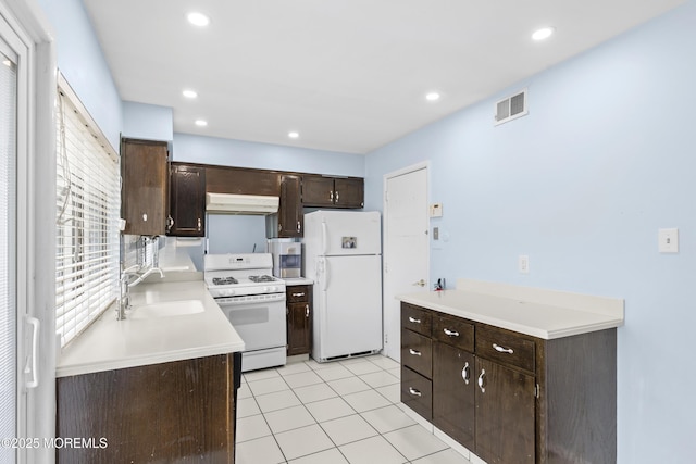 129 Tudor Ct, Lakewood, NJ 08701 - kitchen with white appliances, under cabinet range hood, dark brown cabinetry, light countertops, and light tile patterned floors