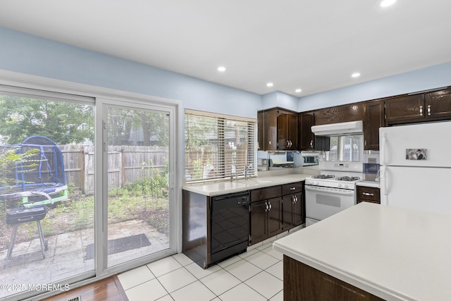 129 Tudor Ct, Lakewood, NJ 08701 - kitchen with white appliances, under cabinet range hood, dark brown cabinets, light countertops, and healthy amount of natural light