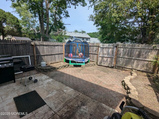 129 Tudor Ct, Lakewood, NJ 08701 - fenced backyard featuring a patio and a trampoline