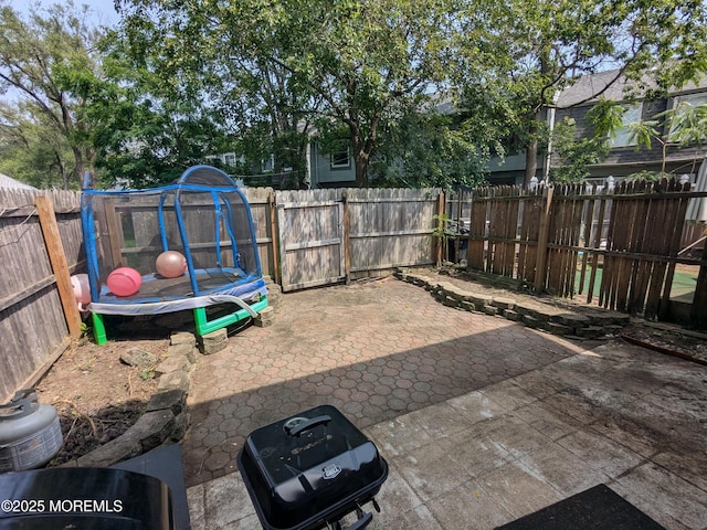 129 Tudor Ct, Lakewood, NJ 08701 - fenced backyard with a patio area and a trampoline