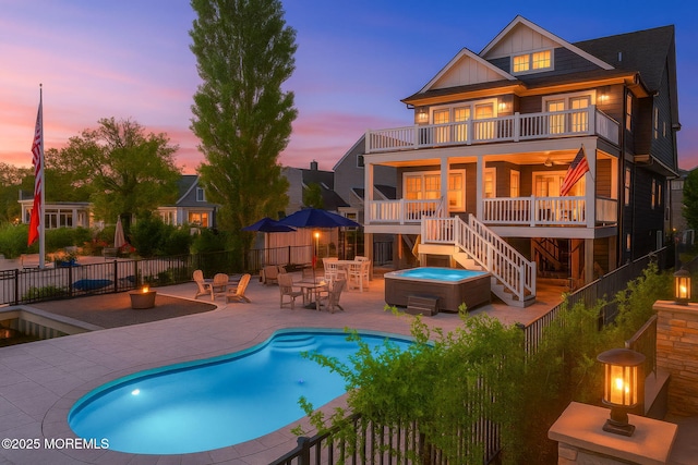2029 Bay Blvd, Ortley Beach, NJ 08751 - back of property at dusk featuring a hot tub, a balcony, board and batten siding, stairs, and a patio