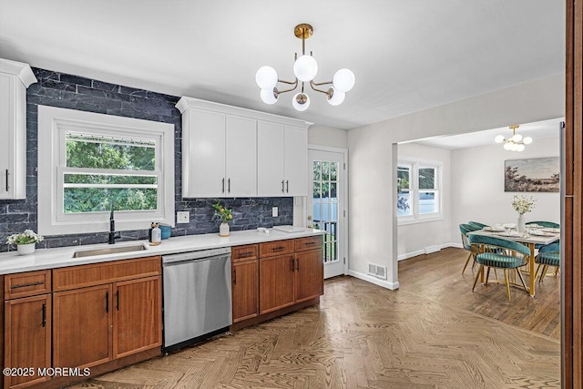 1528 Stuyvesant Ave, Ewing, NJ 08618 - kitchen with stainless steel dishwasher, a chandelier, light countertops, decorative backsplash, and plenty of natural light