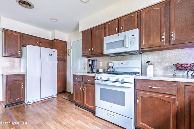 5 Bennington Dr, Toms River, NJ 08757 - kitchen with white appliances, light countertops, backsplash, and light wood finished floors