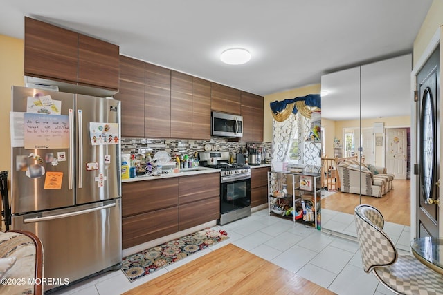 131 W 3rd St, Howell, NJ 07731 - kitchen with stainless steel appliances, backsplash, light countertops, modern cabinets, and light tile patterned floors